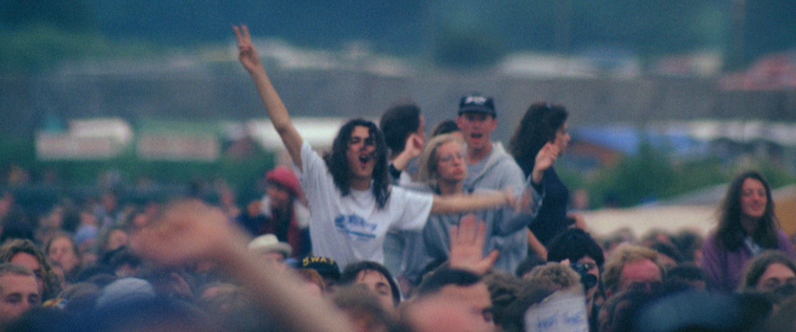 A festival crowd with arms raised, a frame from Glastonbury The Movie
